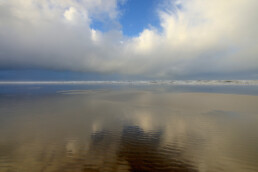 Weerspiegeling wolkenlucht van hagelbui in ondiep water op het Kennemerstrand bij IJmuiden. | © Ronald van Wijk Fotografie